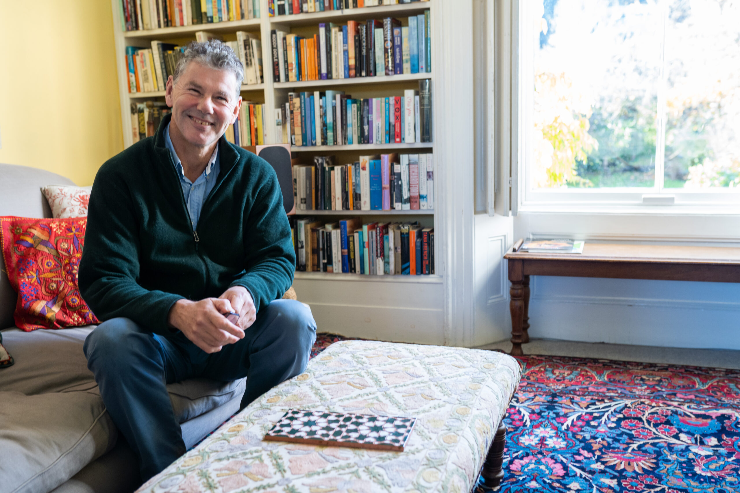 A young man standing with an older man and woman, smiling at the camera as one takes a selfie